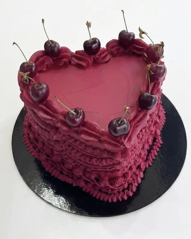 Burgundy vintage heart-shaped cake with piped shells and fresh cherries, a custom cake by Cakes By Vjollca in Pristina, Kosovo