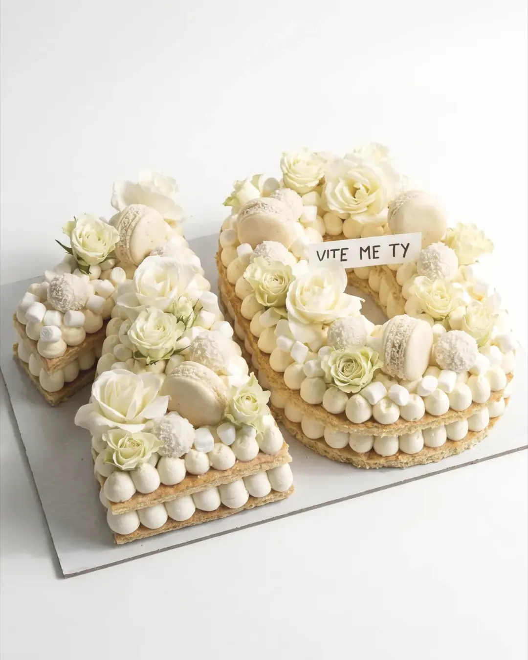Number ten cream tart with white roses, macarons and meringues, a custom cake by Cakes By Vjollca in Pristina, Kosovo