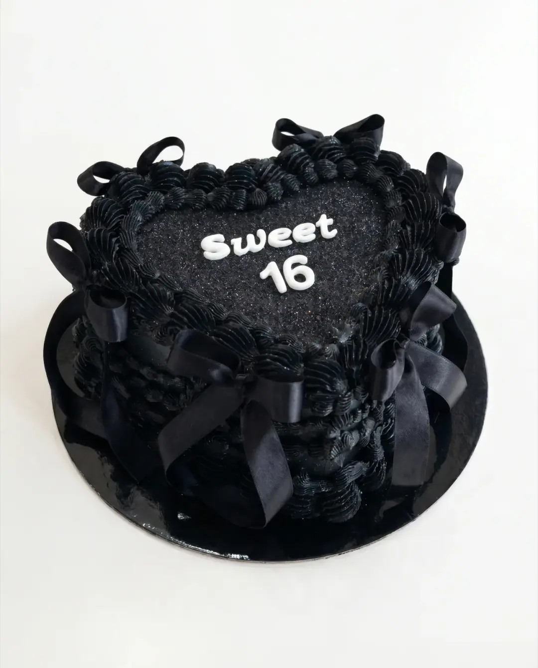 Black vintage heart cake with satin bows for a Sweet 16 birthday, a custom cake by Cakes By Vjollca in Pristina, Kosovo