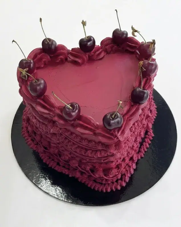 Burgundy vintage heart-shaped cake with piped shells and fresh cherries, a custom cake by Cakes By Vjollca in Pristina, Kosovo