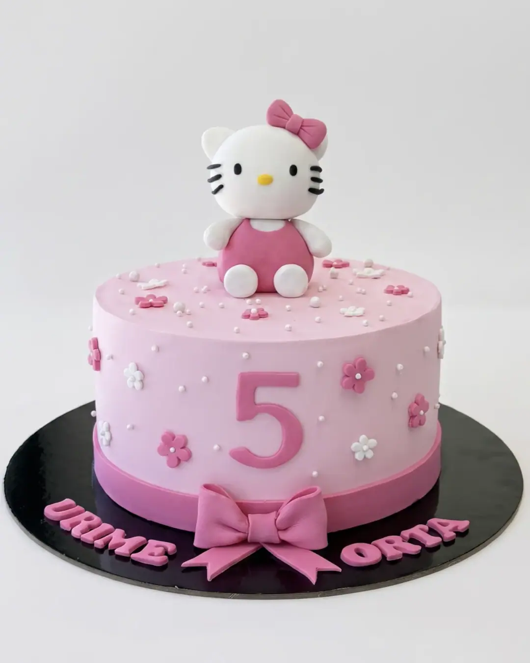 Pink Hello Kitty fifth birthday cake with a fondant figurine and flowers, a custom cake by Cakes By Vjollca in Pristina, Kosovo