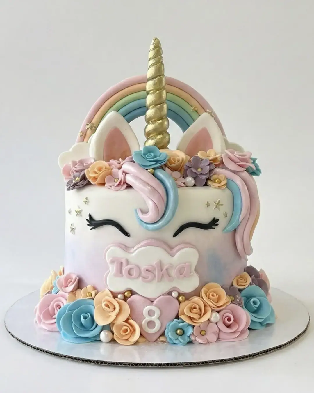 Pastel unicorn birthday cake with a gold horn, rainbow and sugar roses, a custom cake by Cakes By Vjollca in Pristina, Kosovo