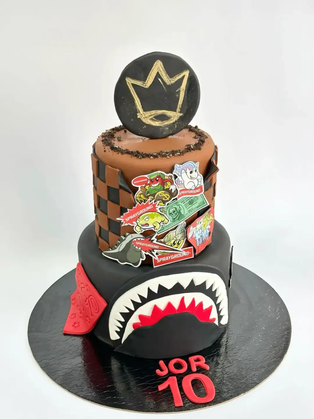Streetwear-themed 10th birthday cake with checkerboard tiers and sticker art, a custom cake by Cakes By Vjollca in Pristina, Kosovo