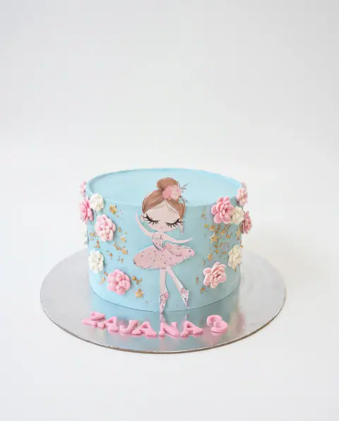 Torte ditëlindjeje në blu të zbehtë me ilustrimin e një balerine me tutu rozë, lule rozë e të bardha të pipuara, fletë ari dhe emrin e moshën e fëmijës mbi tabaka, torte me porosi nga Cakes By Vjollca në Prishtinë