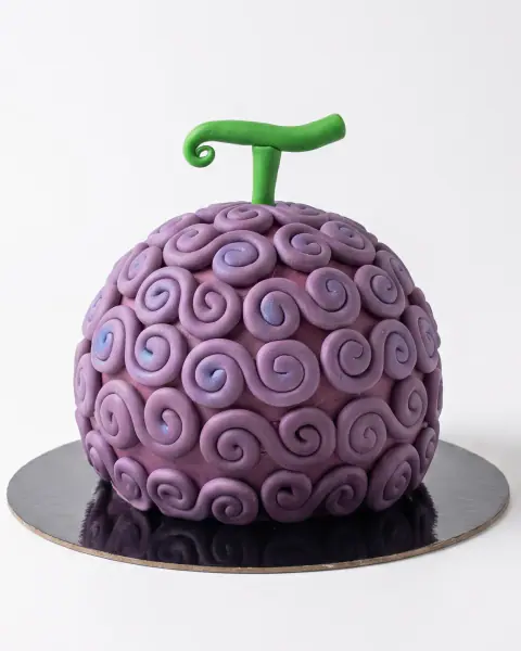 Purple One Piece devil fruit birthday cake, a sculpted sphere covered in fondant swirls with a green stem, a custom cake by Cakes By Vjollca in Pristina, Kosovo